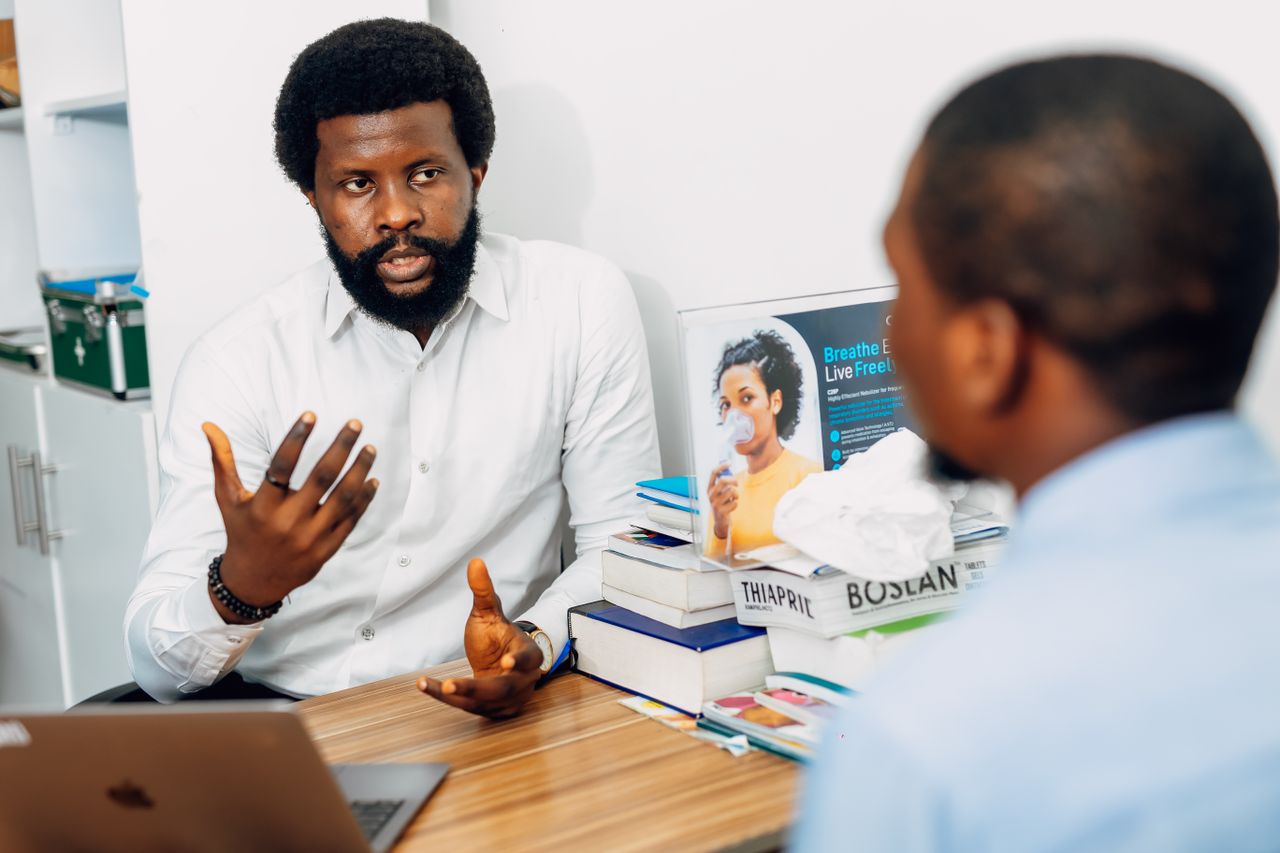 team-03 A doctor discusses health concerns with a patient at a medical office in Lagos, Nigeria.